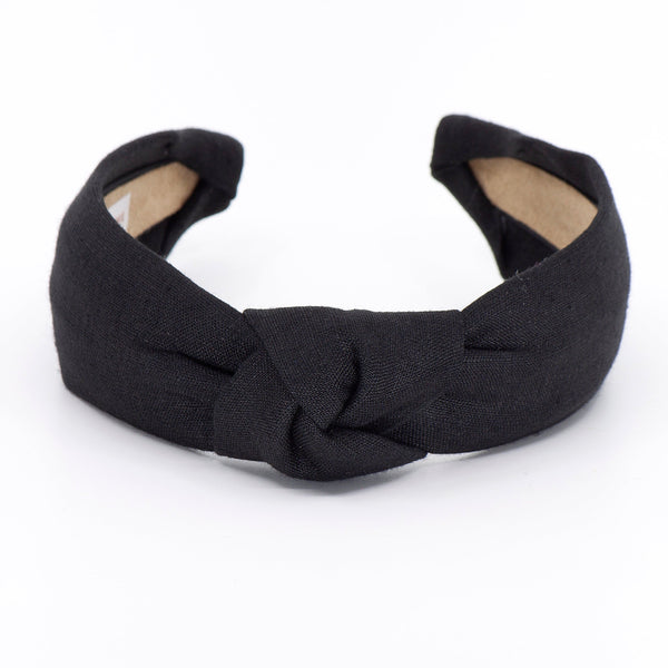 black knotted linen headband on a white background