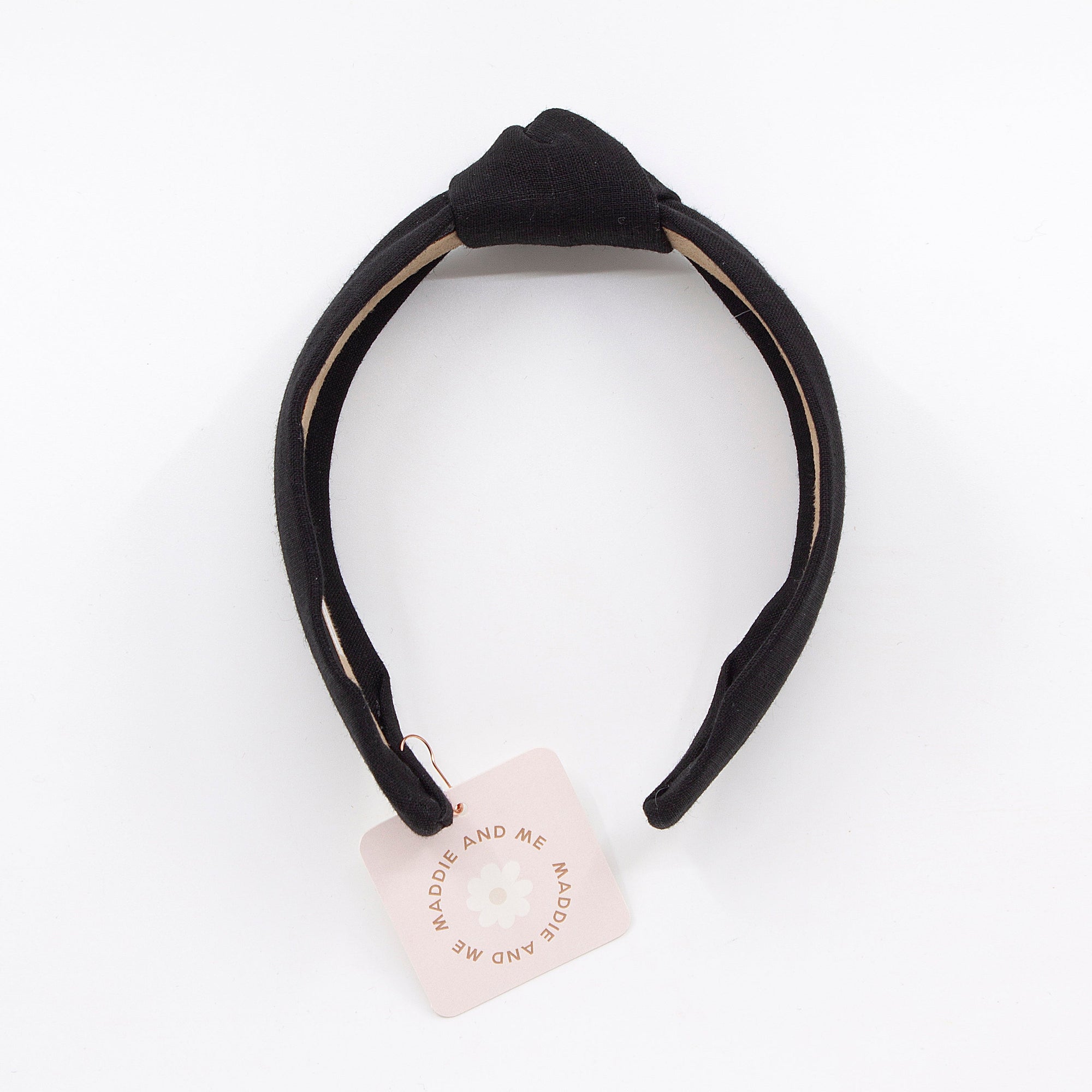 black knotted linen headband on a white background with tag