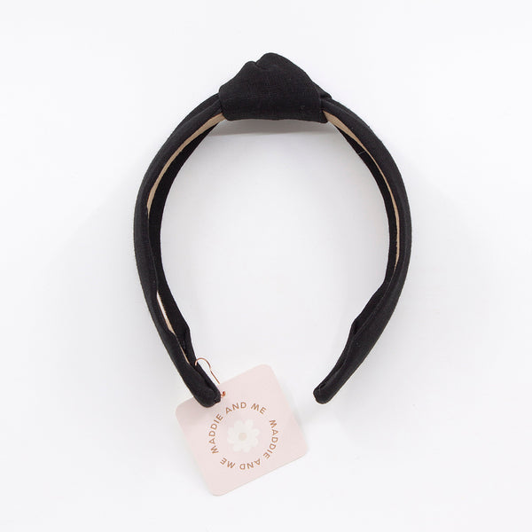 black knotted linen headband on a white background with tag