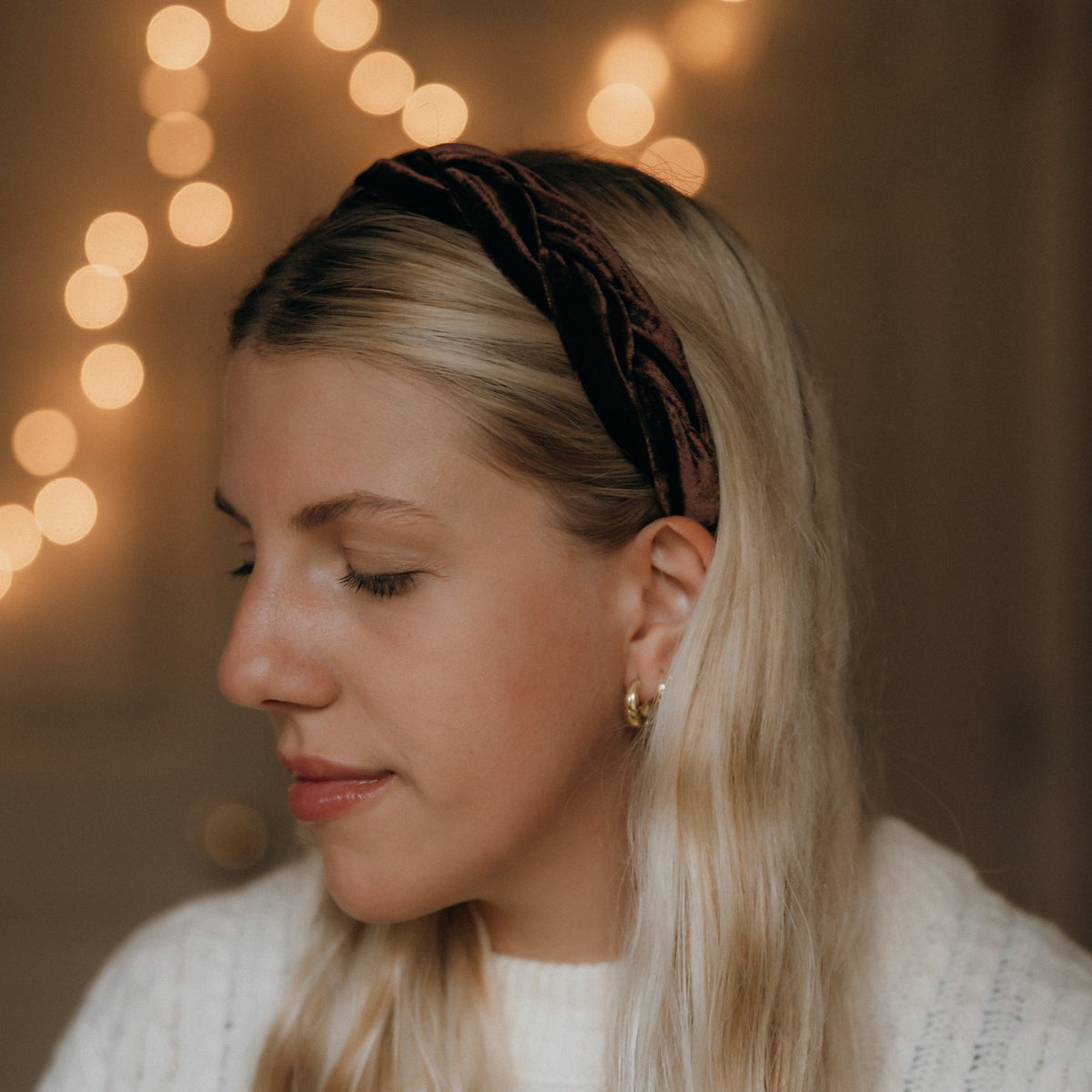 Woman wearing a headband with blurred lights in the background