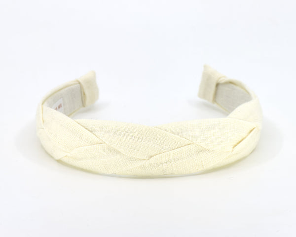 A braided fabric headband in a pale cream or off-white color, shown on a plain white background.