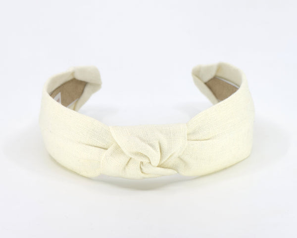 A wide cream linen fabric headband with a knotted center detail, shown on a plain white background.