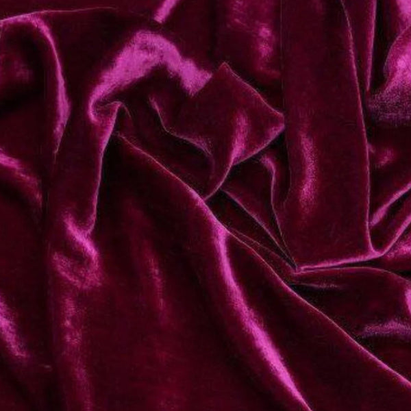 Deep magenta velvet fabric with a soft, plush texture, draped in elegant folds.