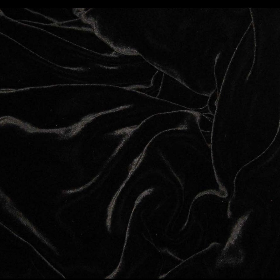 A close-up of black fabric with a soft, slightly sheer texture and flowing folds.