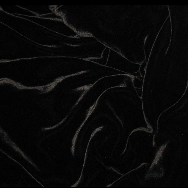 A close-up of black fabric with a soft, slightly sheer texture and flowing folds.