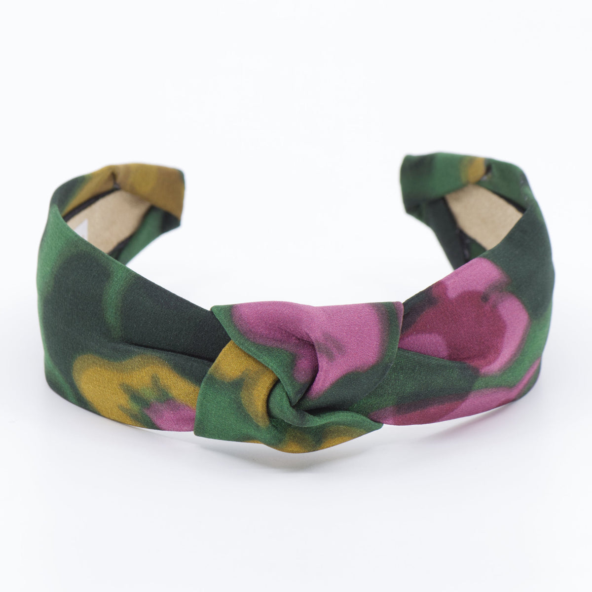 A fabric headband with a knotted center, featuring a green, pink, and yellow floral pattern, shown on a plain white background.