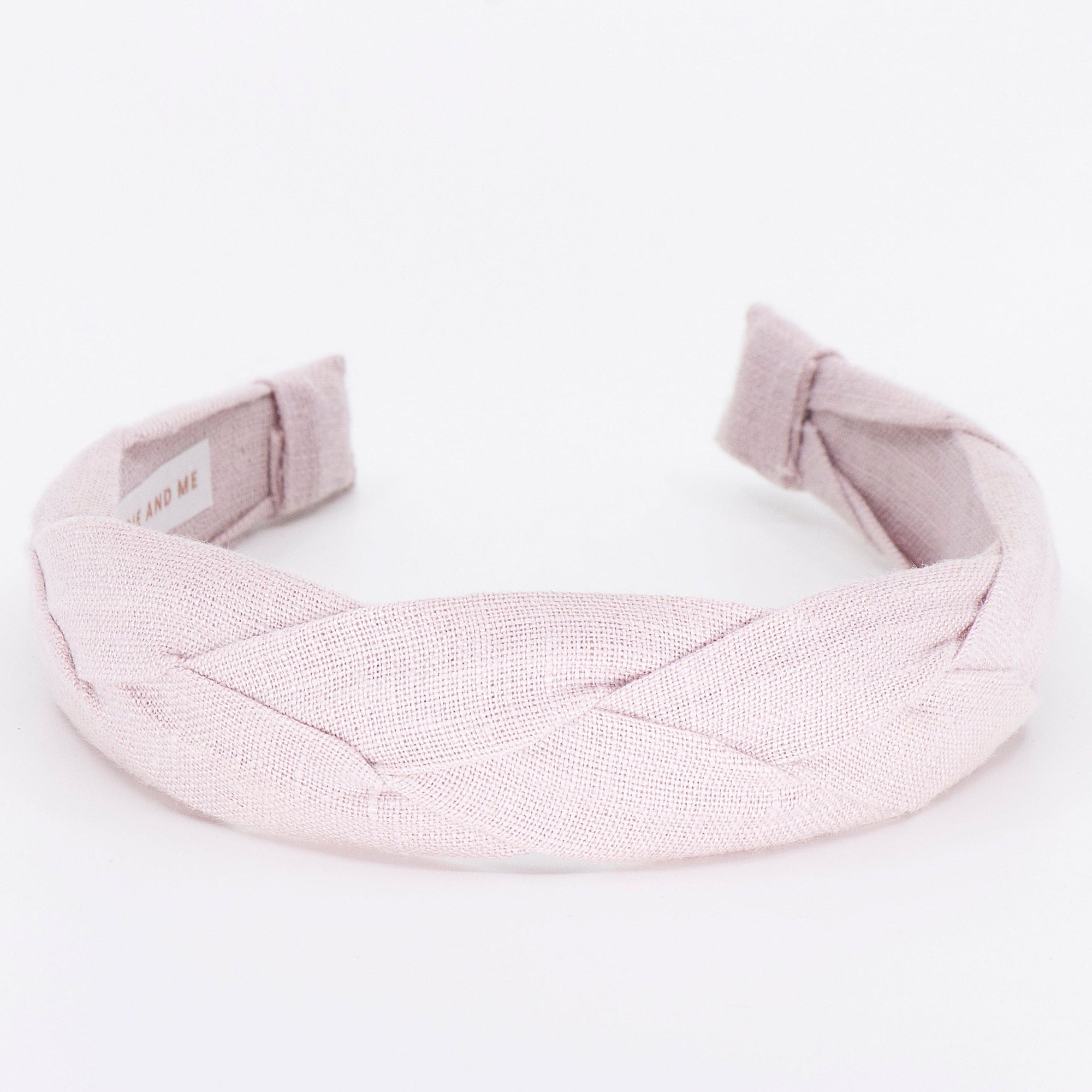light pink braided headband on a white background