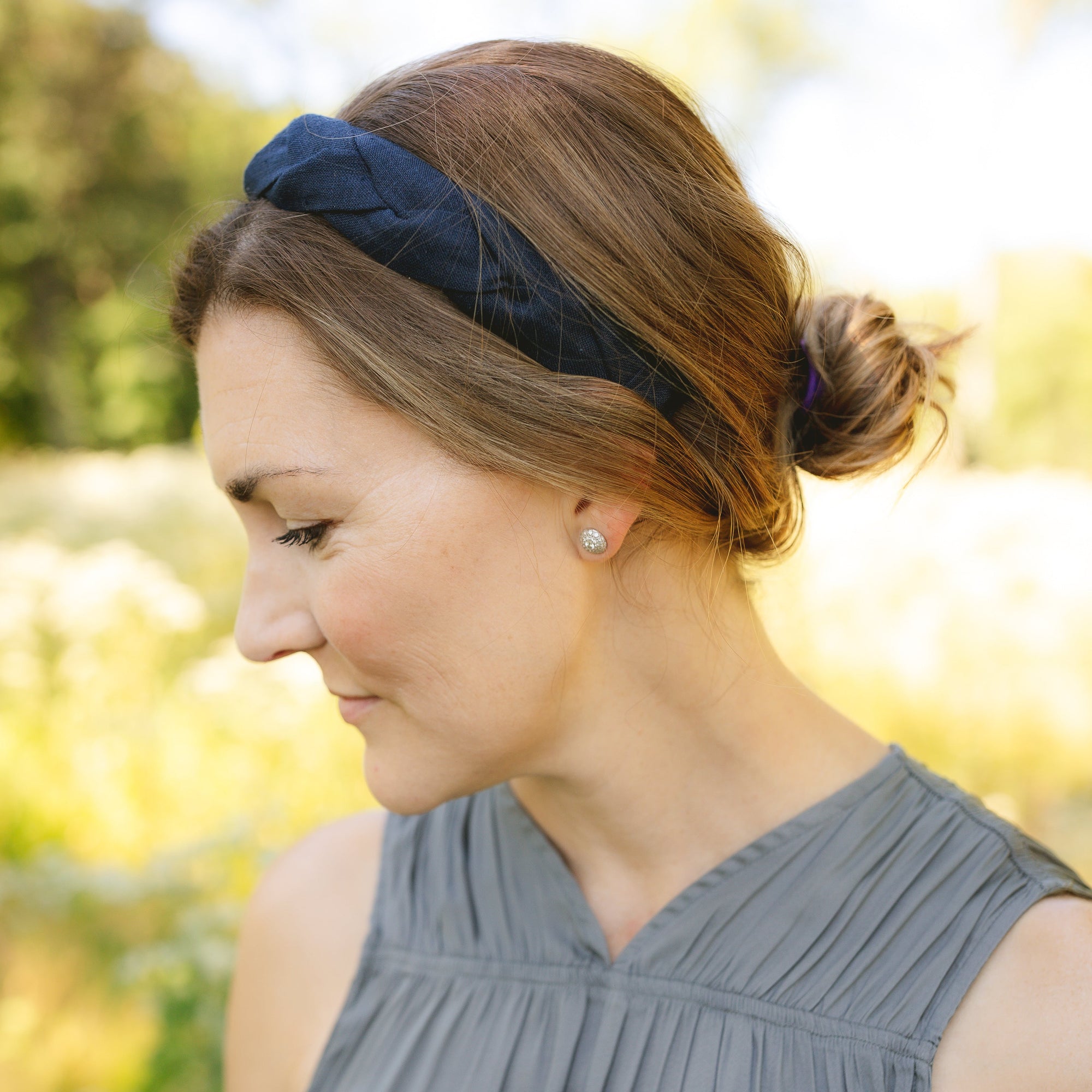 Woman wearing a navy headband in a natural setting