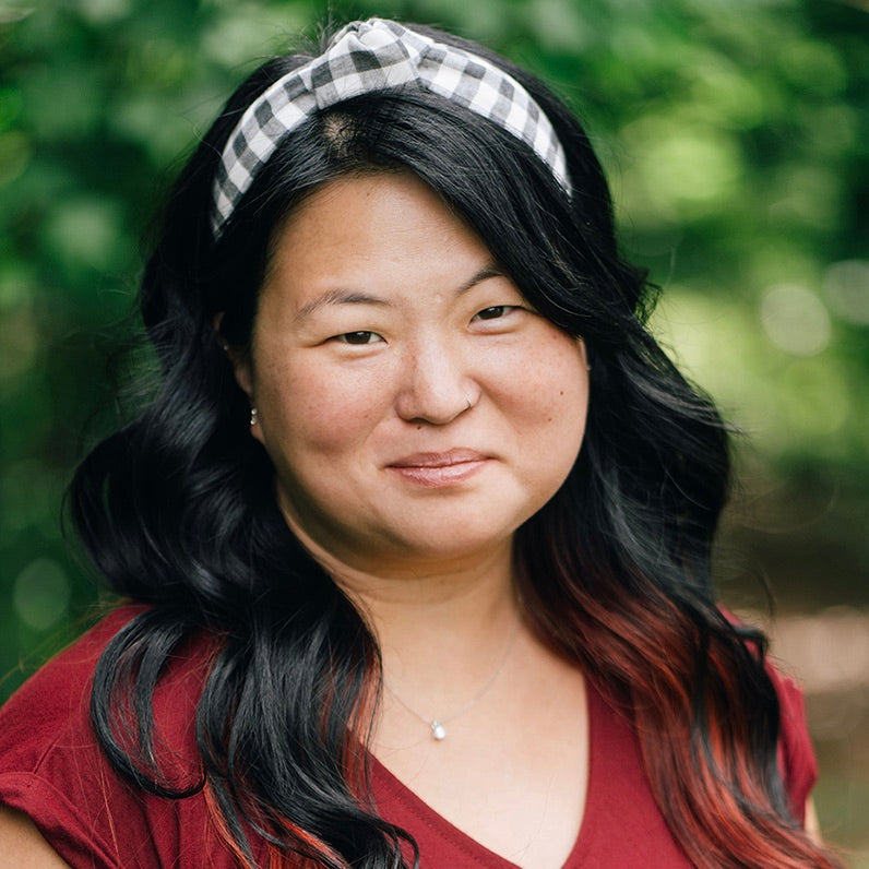 Woman wearing black and white check headband in a natural setting