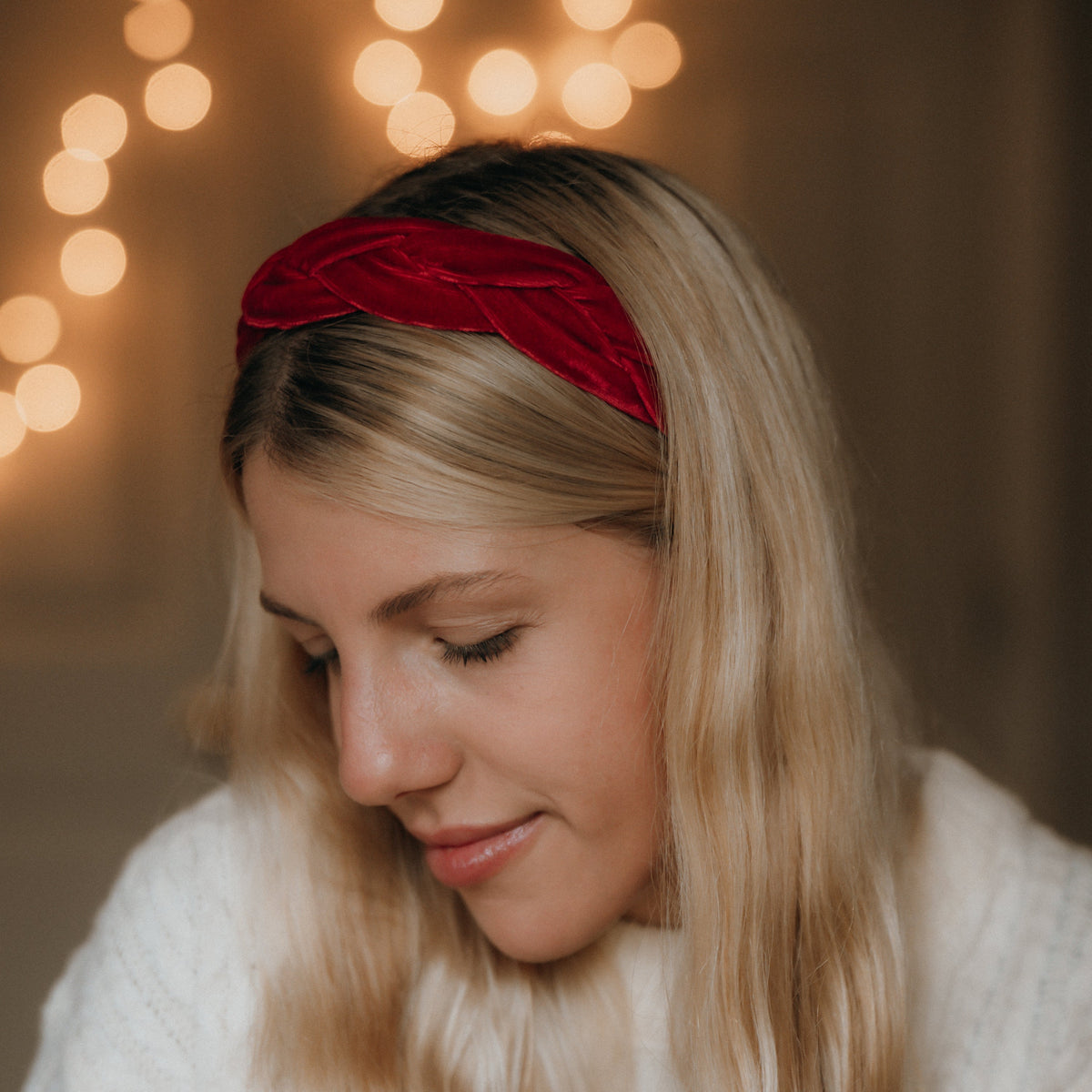 Woman wearing a red headband with blurred lights in the background