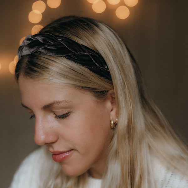 Woman wearing a velvet headband with blurred lights in the background