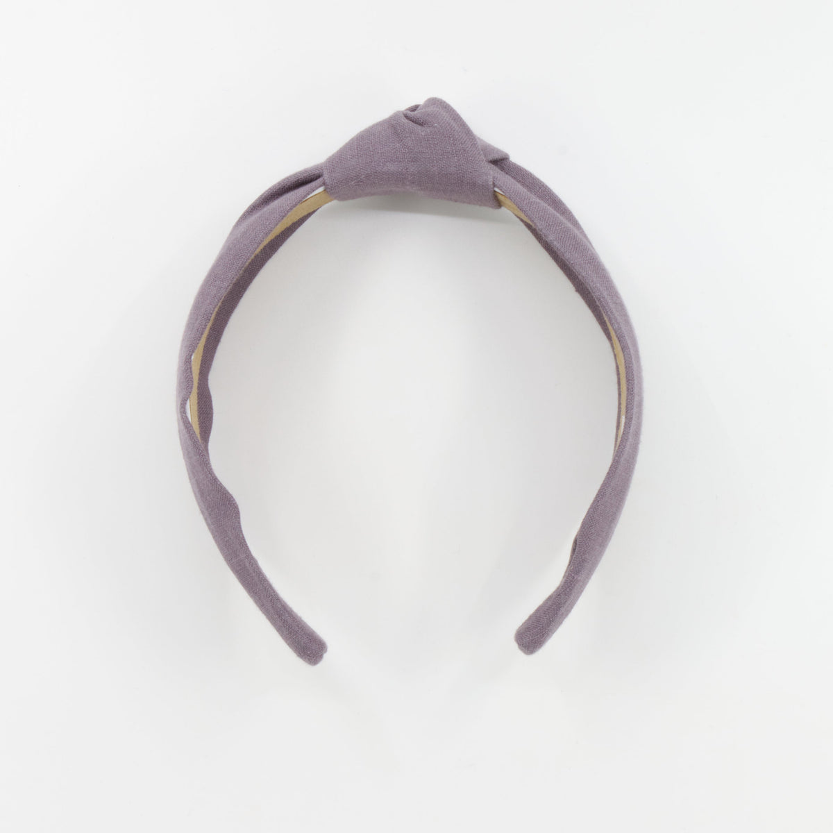 A dusty purple fabric headband with a knotted top detail, displayed on a clean white background.