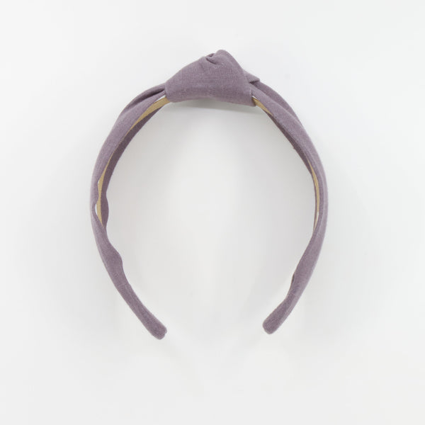 A dusty purple fabric headband with a knotted top detail, displayed on a clean white background.