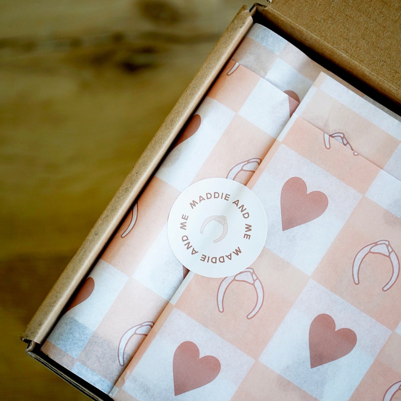 Branded tissue paper with sticker in a box.