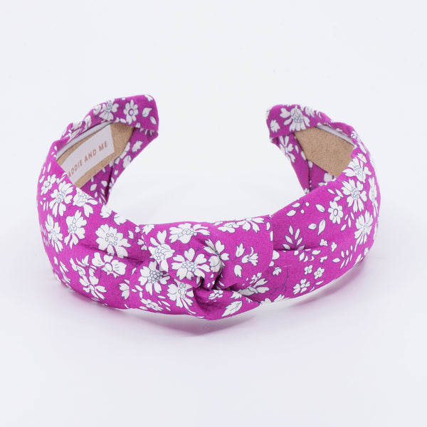Bright pink floral headband on a white background
